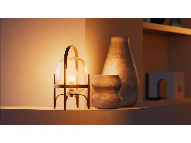 Decorative lamp and vases on a shelf with warm lighting from the Philips Hue A60 White Globe