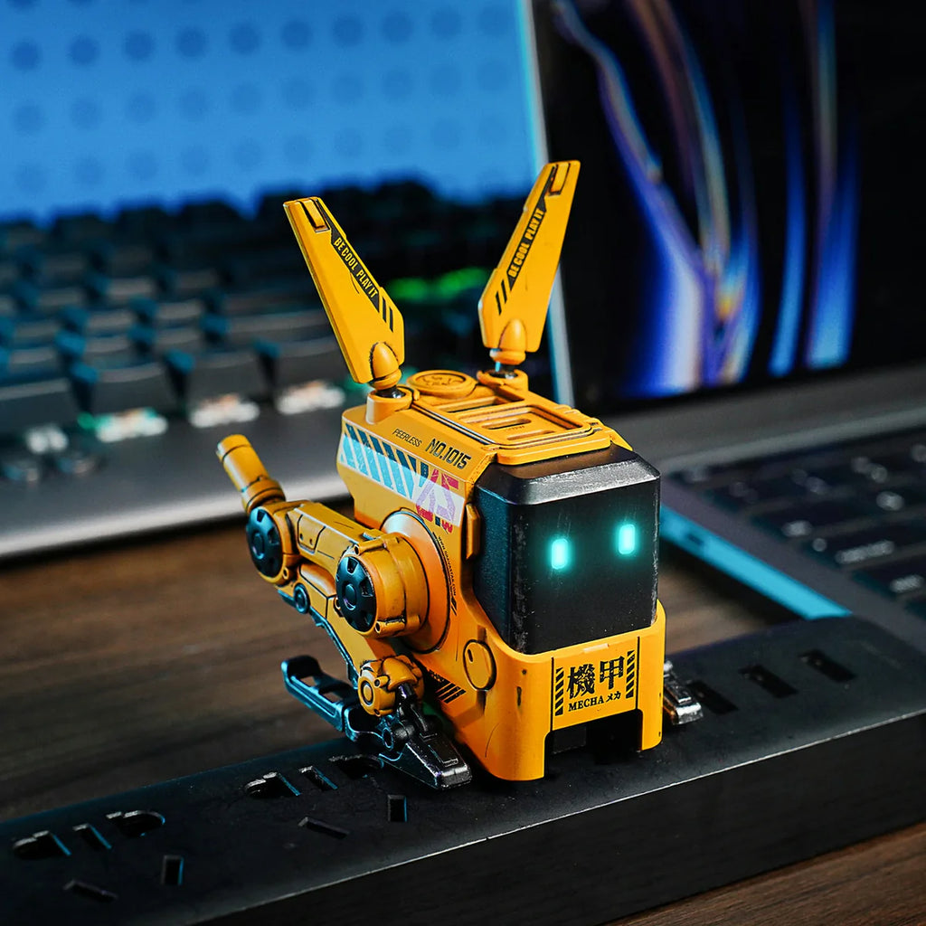 Yellow robot toy on a desk with a laptop in the background