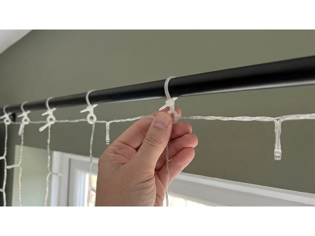 Philips Hue Festavia Curtain Lights being hung on a curtain rod