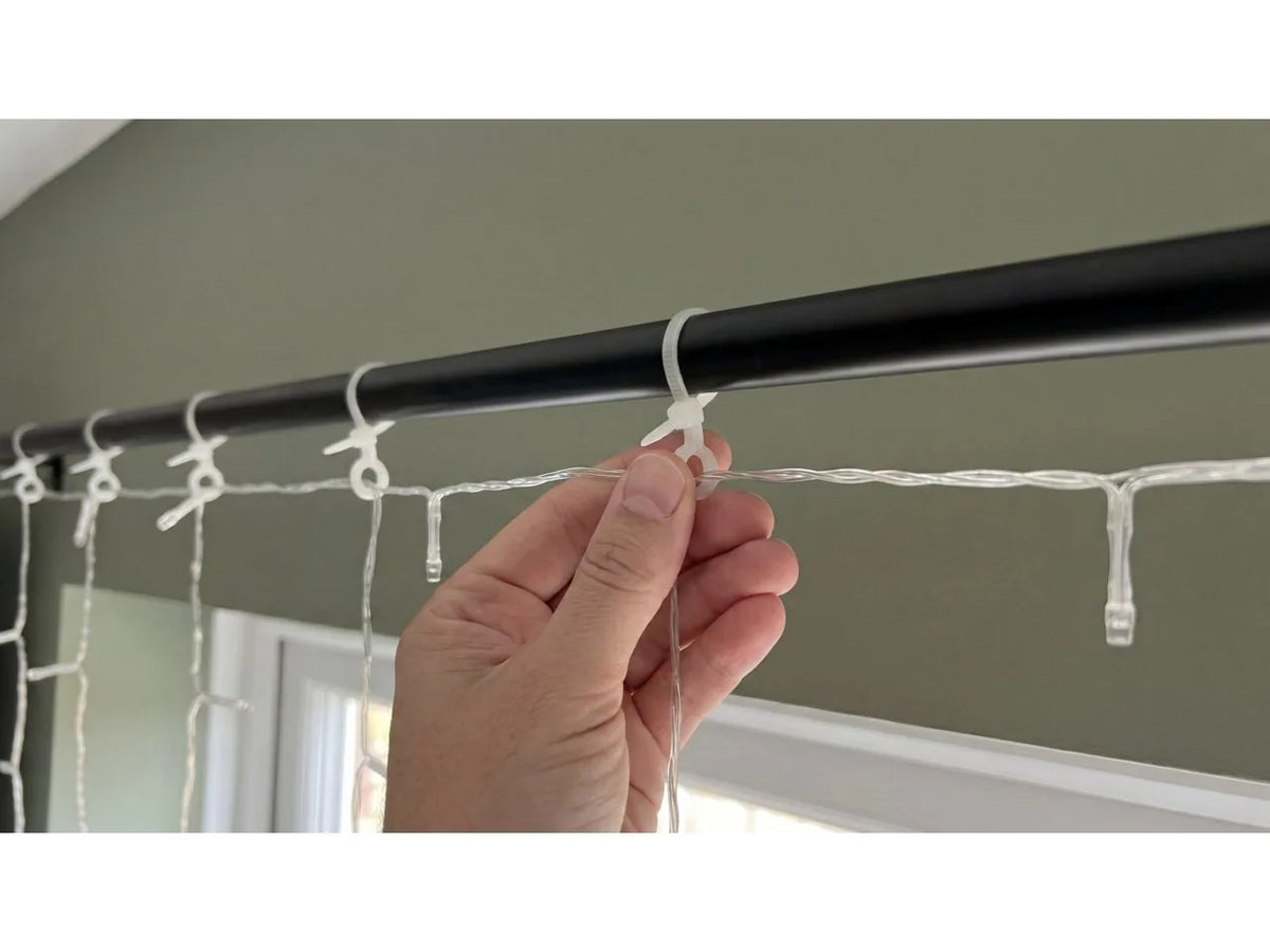 Philips Hue Festavia Curtain Lights being hung on a curtain rod
