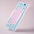Colorful keyboard with pink and blue keys on a light pink background