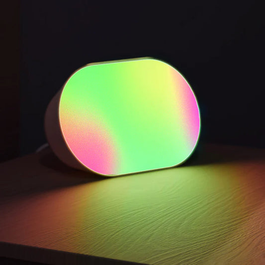 Colorful, rounded  lifx luna lamp casting a shadow on a dark surface