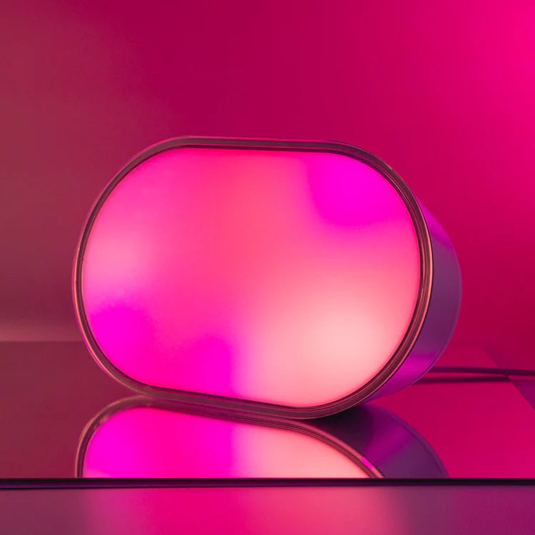 Pink and purple gradient light on a reflective surface with a pink background