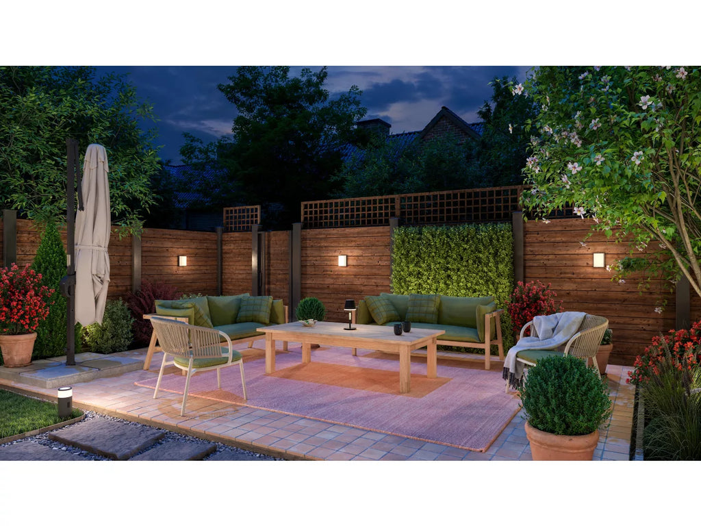 Philips Hue Scenova Wall Light in garden setting with outdoor furniture