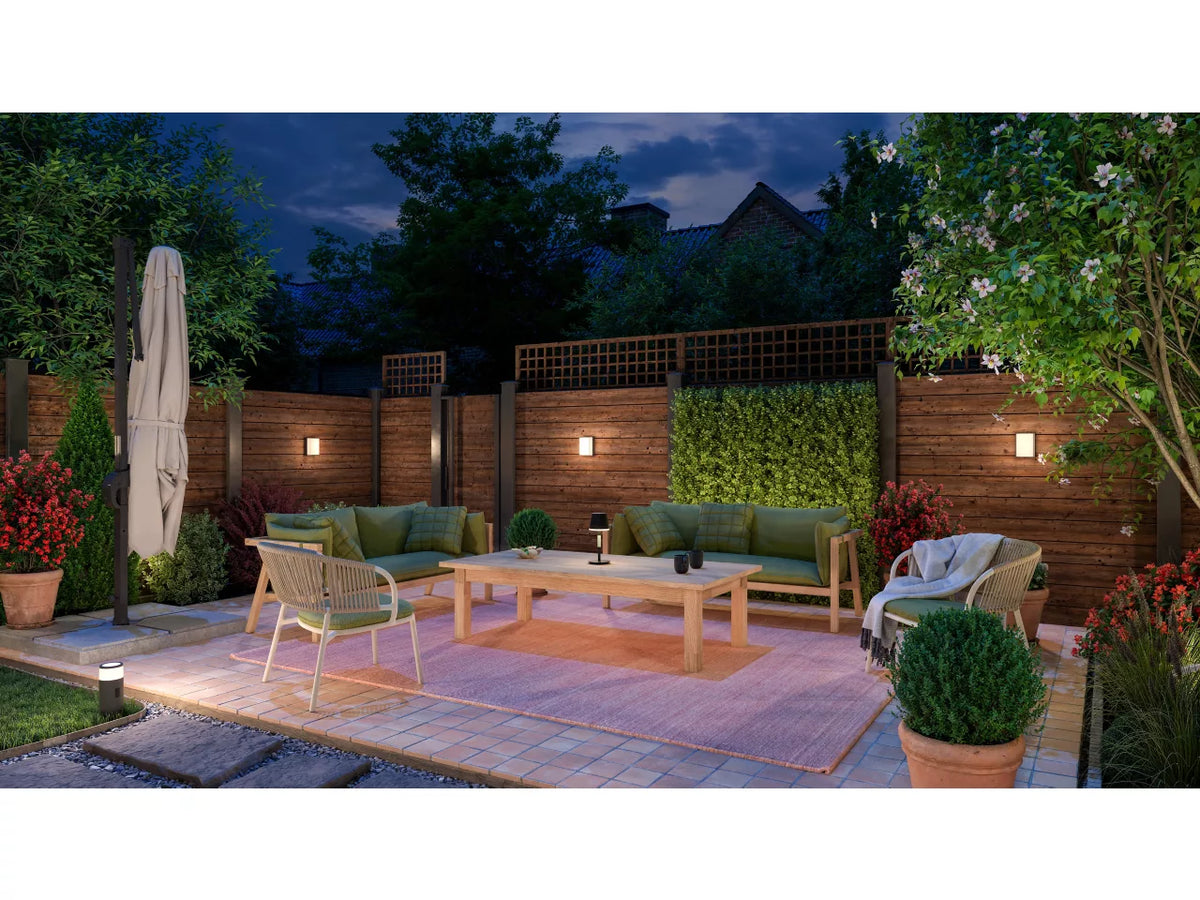 Philips Hue Scenova Wall Light in garden setting with outdoor furniture