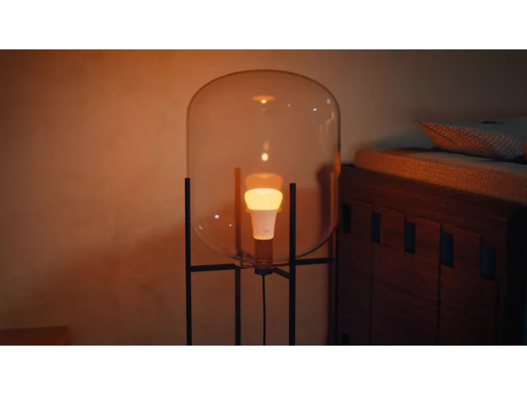 Floor lamp with a glass shade in a dimly lit room