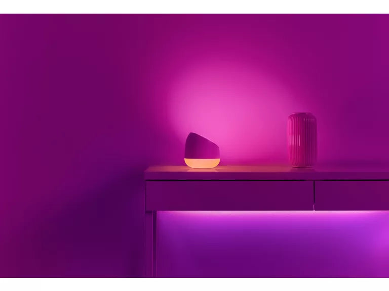 Wiz Squire  Two decorative vases on a wooden surface with a vibrant purple glow against a matching purple background.