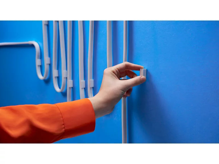 Wiz Smart Flex  Hand holding a white plastic component against a blue background