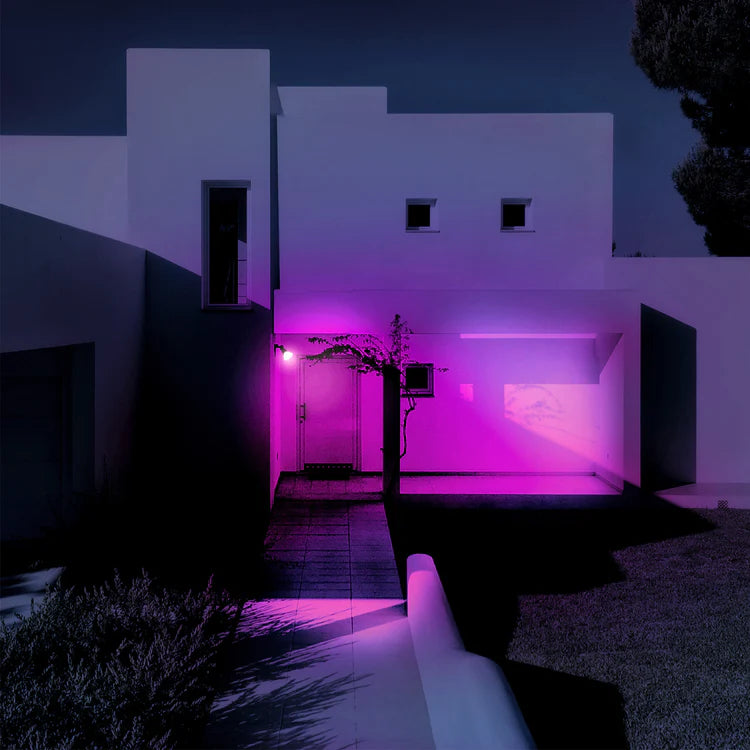 Modern house exterior with pink lighting at night