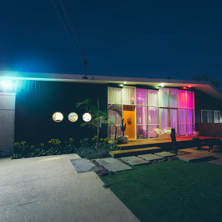 Modern house exterior with colorful interior lights at night