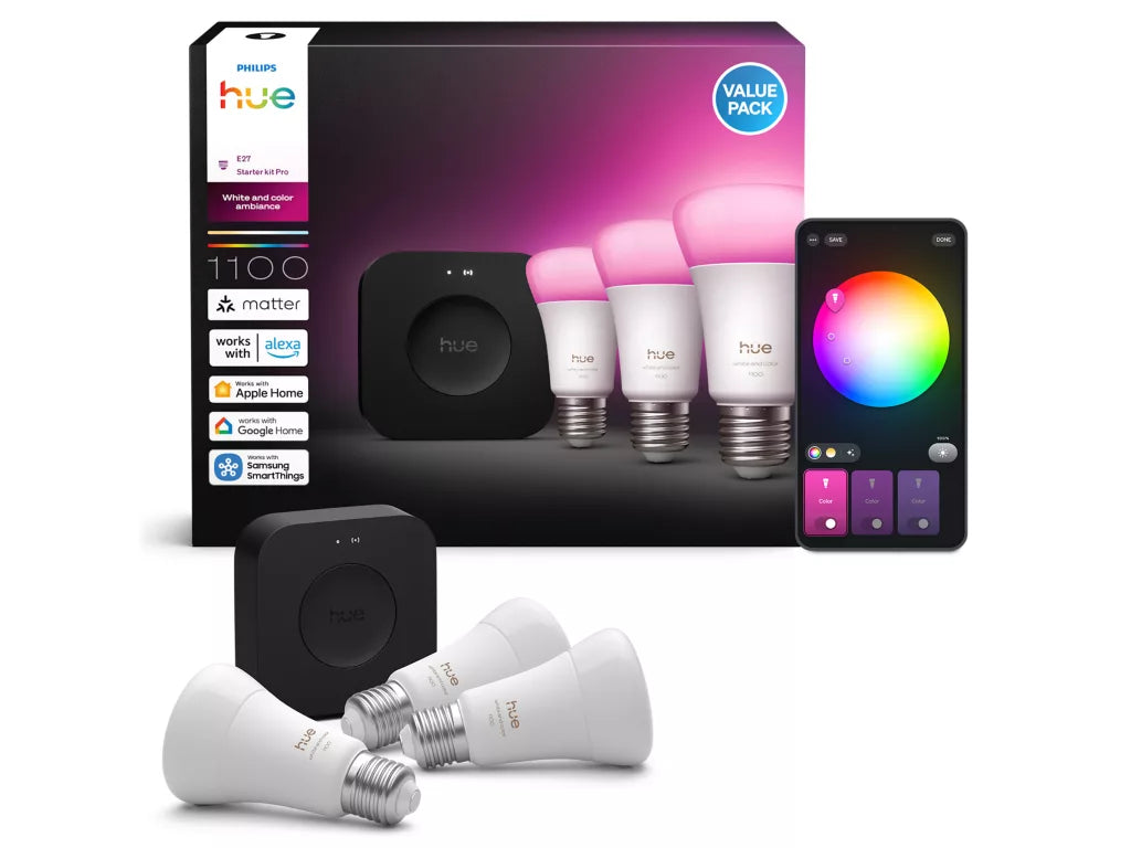 Philips Hue smart lighting system with bulbs, hub, and smartphone app on a white background