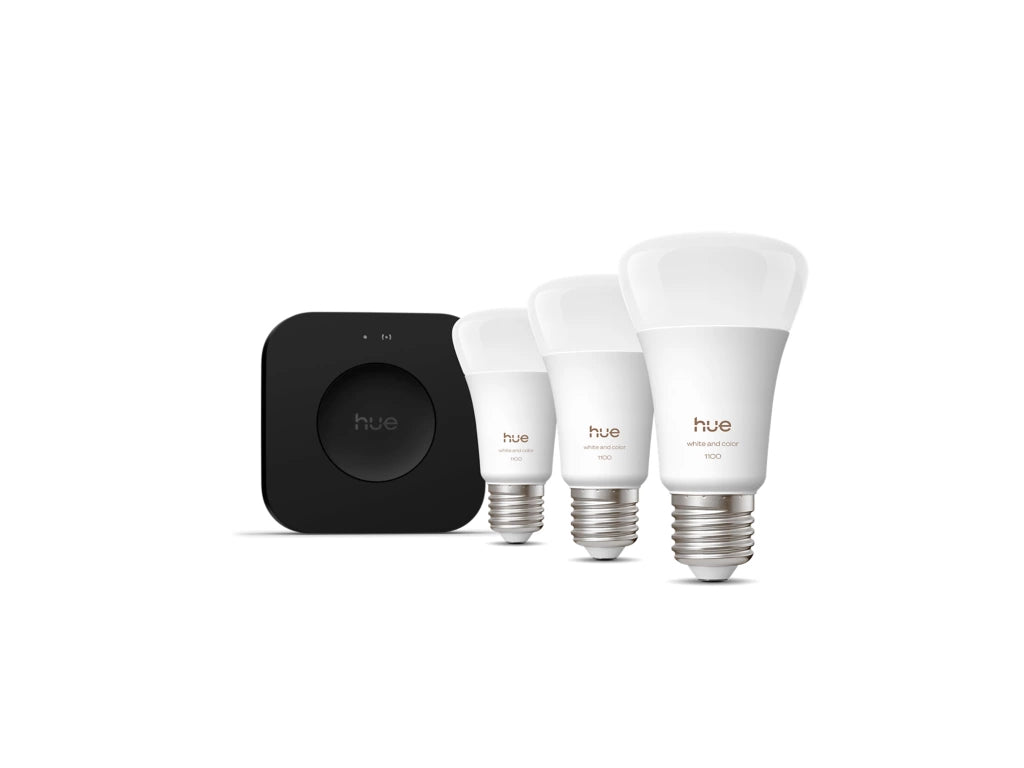 Philips Hue smart lighting system with a hub and three bulbs on a white background